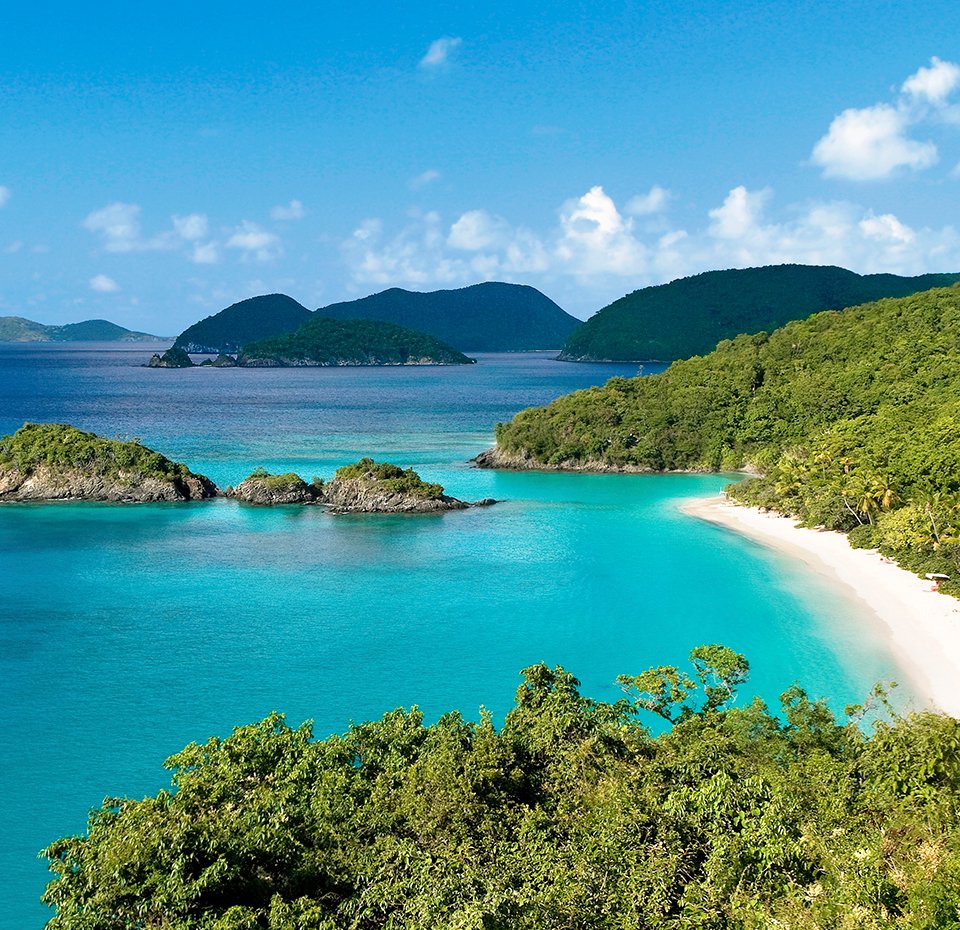 A pristine tropical beach with turquoise waters and lush green hills | MSC Cruises