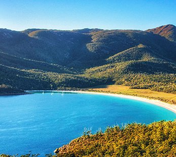 Pristine tropical bay with clear blue ocean water and coastal mountains | MSC Cruises