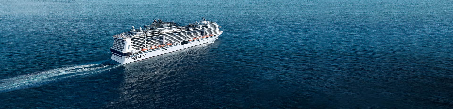 An MSC cruise ship sailing across calm blue waters | MSC Cruises