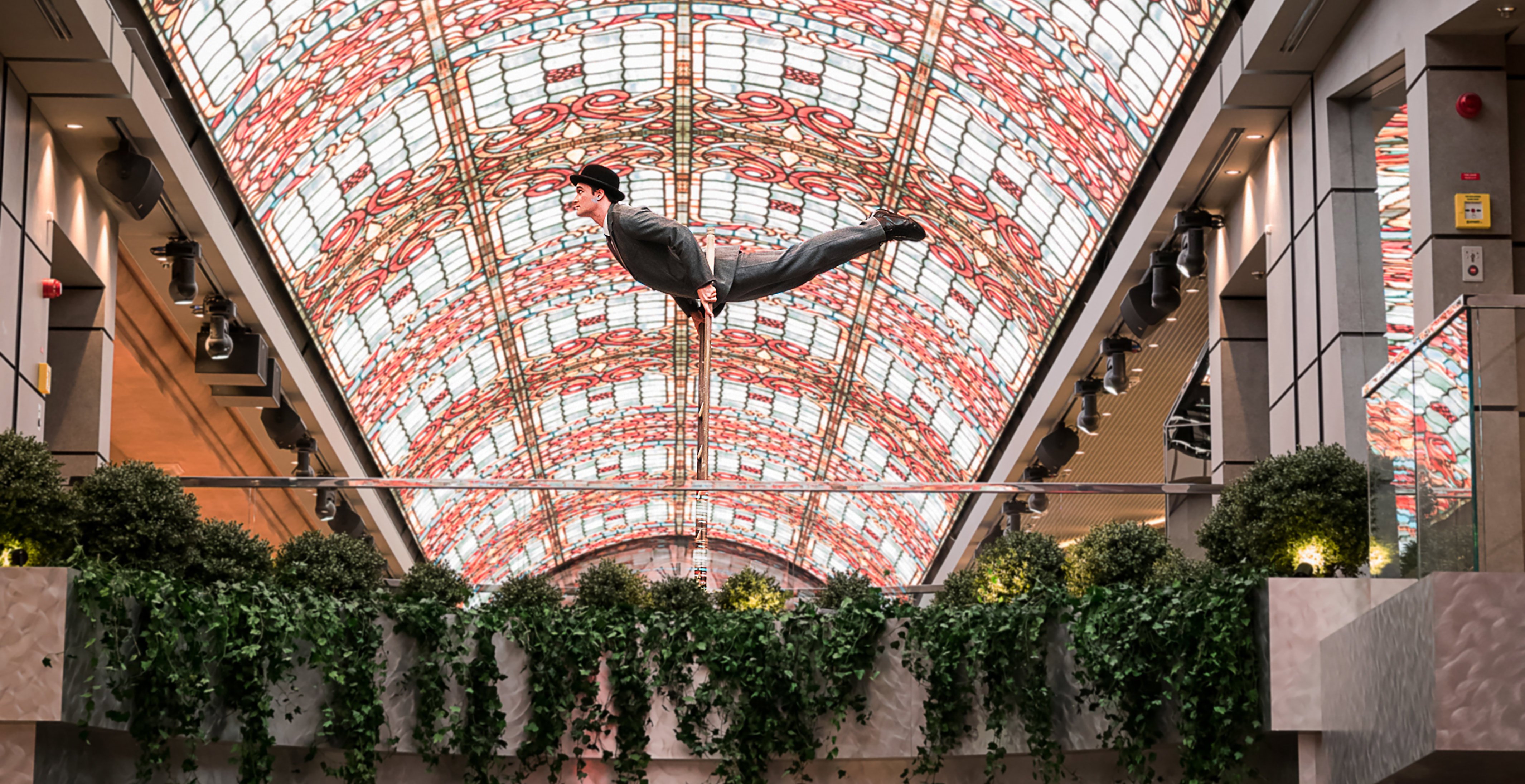 Acrobat performing in a vibrant atrium with a stained-glass ceiling onboard | MSC Cruises