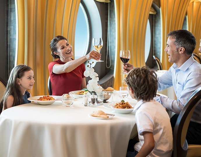 Family dining in an elegant cruise ship restaurant with ocean views | MSC Cruises Family dining in an elegant cruise ship restaurant with ocean views | MSC Cruises